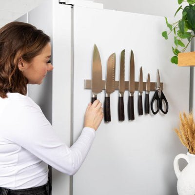 femme place couteau sur barre aimantée pour couteaux