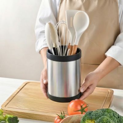 pot à ustensiles cuisine entre les mains chef
