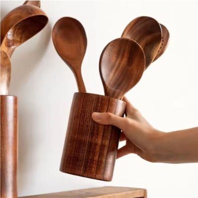 pot à ustensiles cuisine déposé par main sur comptoir