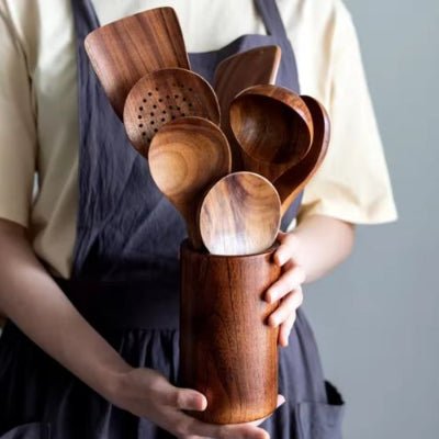 personne tient dans mains pot à ustensiles cuisine en bois