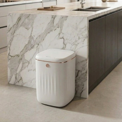 Poubelle automatique blanc perlé ligne dorée élégante contre îlot marbre