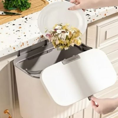 avec assiette main met restes alimentaires poubelle cuisine sous évier