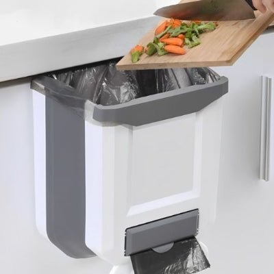 jetant restes légumes depuis une planche poubelle cuisine sous evier