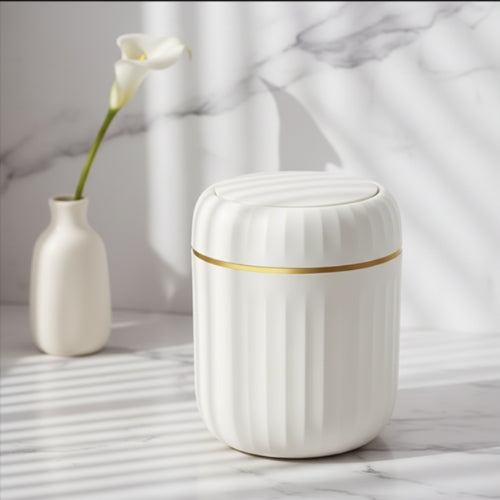 poubelle de table avec liseré doré et vase à côté