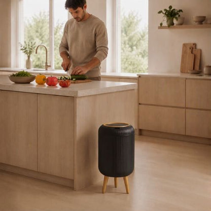 poubelle design installée devant un homme cuisinant dans une cuisine
