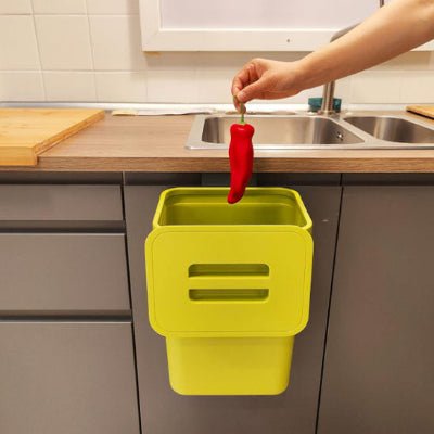 poubelle sous évier verte jetant poivron rouge démonstration